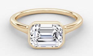 East-west bezel set emerald cut lab-grown diamond ring in yellow and white gold
